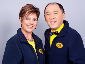 Smiling faces, warm and friendly - Caroline and Alan Vandome are Magic Party HQ - Children's party entertainment business in Hampshire - wearing company logowear