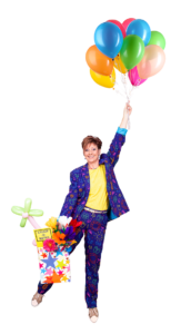 Hampshire female children's party entertainer, Magic Wanda, is smiling holding a bunch of colourful balloons and a bag of fun party goodies and being pulled up and away by the balloons. into the air.