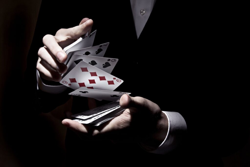 Magician shuffling cards with the spotlight on it - Magician for older children